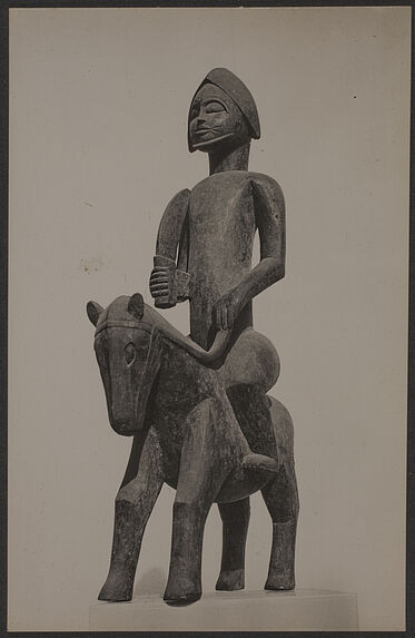 Sculpture sur bois d'un génie à cheval, armé d'un sabre