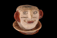 Objet en céramique : tête humaine sur une assiette