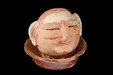 Objet en céramique : tête humaine sur une assiette