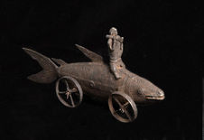 Statuette de personnage sur poisson à roulettes