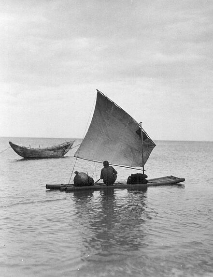 Pêcheur au filet sur un petit radeau de bambou