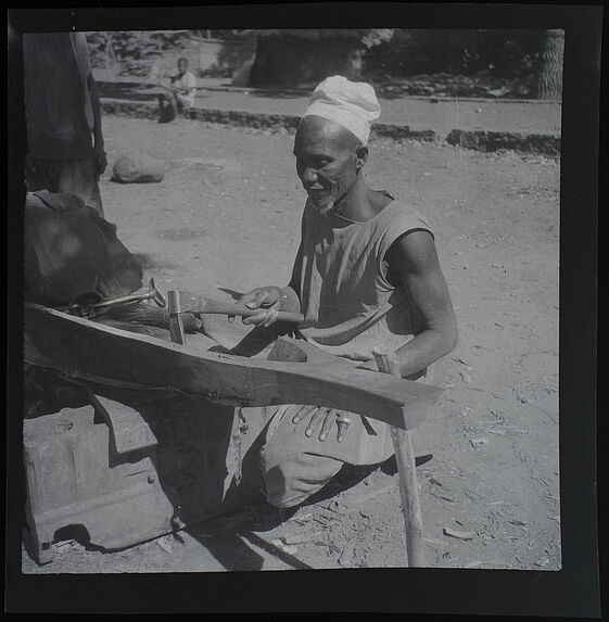 Travail à l' herminette sur une pirogue